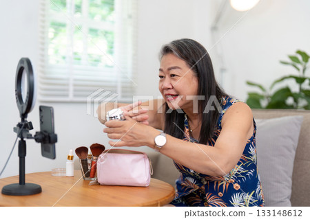 Beauty and Self-Care. Mature woman demonstrating skincare routine on video call. Beauty and Self-Care. Mature woman demonstrating skincare routine on video call. 133148612