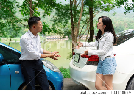 Insurance Dispute. Two individuals discussing vehicle damage and insurance coverage outdoors. 133148639