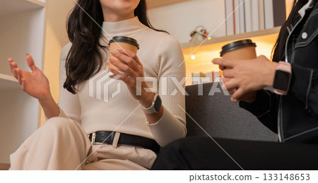 Women enjoying coffee and conversation in a podcast studio 133148653