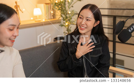 Heartfelt Connection. Woman expressing joy during a podcast conversation with a friend. Heartfelt Connection. Woman expressing joy during a podcast conversation with a friend. 133148656