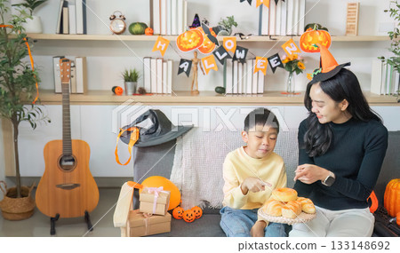 Halloween Treats. A mother and son enjoy festive snacks during Halloween celebrations. Halloween Treats. A mother and son enjoy festive snacks during Halloween celebrations. 133148692