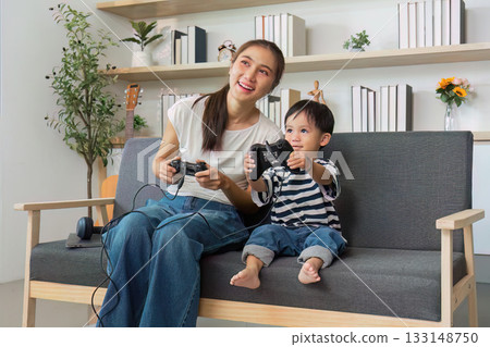 Quality Time. Mother and son playing video games on the couch. Quality Time. Mother and son playing video games on the couch. 133148750