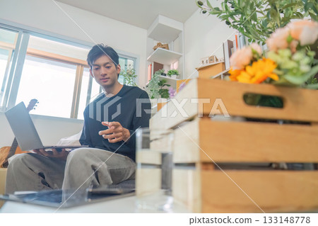 Remote Work. Young man engaged in online meeting at home with laptop. Remote Work. Young man engaged in online meeting at home with laptop. 133148778