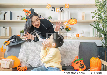 Halloween Fun. A mother and son share a playful moment with festive decorations. 133148808