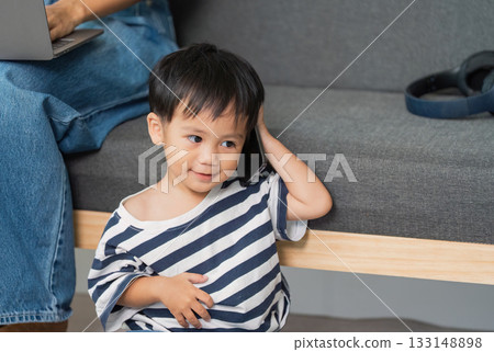 Child Enjoying Phone Call. Young boy smiling while holding phone. 133148898