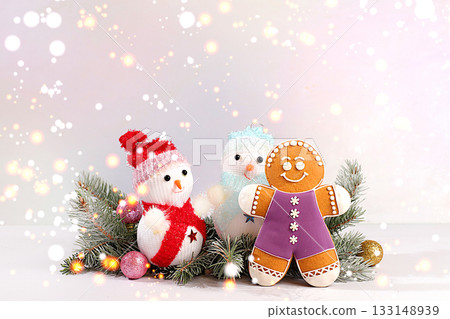 Happy New Year. Festive winter greeting card, gingerbread, snowmen and Christmas ornaments on snowy fir branches, Christmas Eve concept, New Year's background with lights and decorations Happy New Year. Festive winter greeting card, gingerbread, snowmen and Christmas ornaments on snowy fir branches, Christmas Eve concept, New Year's background with lights and decorations 133148939
