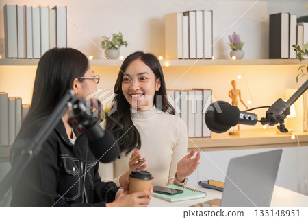 Podcast Discussion. Two women engaging in a lively conversation in a modern studio. Podcast Discussion. Two women engaging in a lively conversation in a modern studio. 133148951