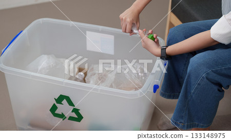 Recycling initiative. Woman sorting plastic bottles for recycling. Recycling initiative. Woman sorting plastic bottles for recycling. 133148975