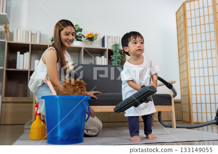 Child Engaging in Household Cleaning with Parent 133149055