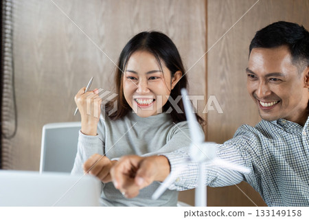 Sustainable teamwork and collaboration. Excited professionals celebrating success in eco-friendly office. 133149158