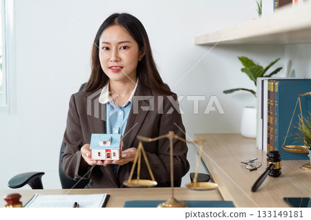 Real Estate Lawyer Holding Model House in Office 133149181