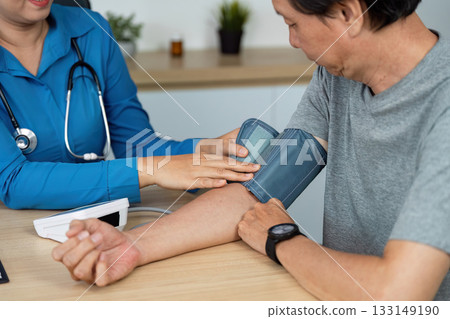 Doctor measuring blood pressure of a male patient in a clinical setting Doctor measuring blood pressure of a male patient in a clinical setting 133149190