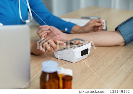 Doctor monitoring patient health with medical equipment in a clinical environment 133149192