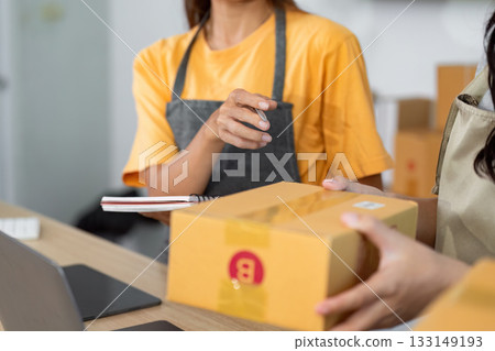 Small Business Collaboration. Team members exchanging packages in a retail environment. 133149193