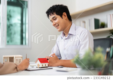 Real Estate Consultation. Agent and Client Discussing Property Options with Models. Real Estate Consultation. Agent and Client Discussing Property Options with Models. 133149212