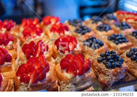 Detailed pastry shot highlighting blueberry and strawberry toppings, flaky dough and golden glazing. Great for sensory food marketing and product pages Detailed pastry shot highlighting blueberry and strawberry toppings, flaky dough and golden glazing. Great for sensory food marketing and product pages 133149235