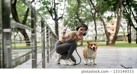 Active Lifestyle. Young Woman Exercising with Corgi in Park Active Lifestyle. Young Woman Exercising with Corgi in Park 133149333