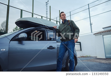 Man With Car Roof Box Ready For Travel In Parking Lot Man With Car Roof Box Ready For Travel In Parking Lot 133149350