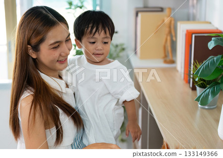 Cleaning with Joy. A mother and child engaging in playful cleaning activities at home. Cleaning with Joy. A mother and child engaging in playful cleaning activities at home. 133149366