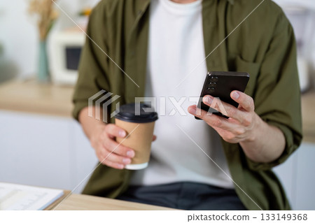 Working from Home. Checking Messages with Coffee in Hand Working from Home. Checking Messages with Coffee in Hand 133149368