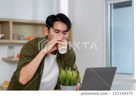 Working from Home. Enjoying Coffee While Focused on Laptop Working from Home. Enjoying Coffee While Focused on Laptop 133149375