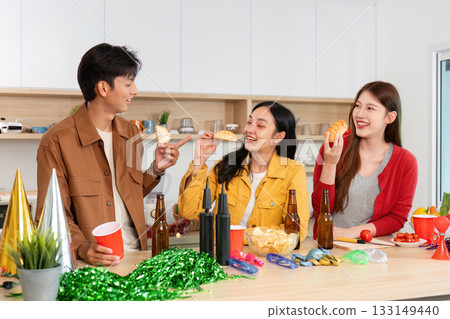 Friends enjoying snacks and drinks at a lively party 133149440