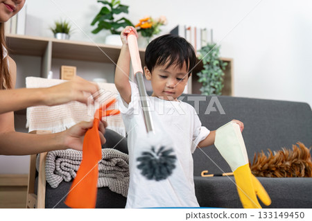 Child Playing with Cleaning Tools During Household Chores Child Playing with Cleaning Tools During Household Chores 133149450