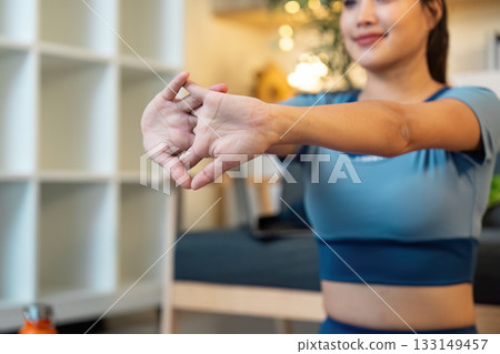 Stretching and Flexibility. Young woman performing hand stretches at home. 133149457