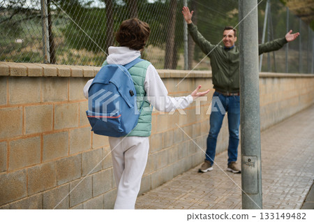 Teenager With Blue Backpack Greets Man On Sidewalk During Friendly Exchange 133149482