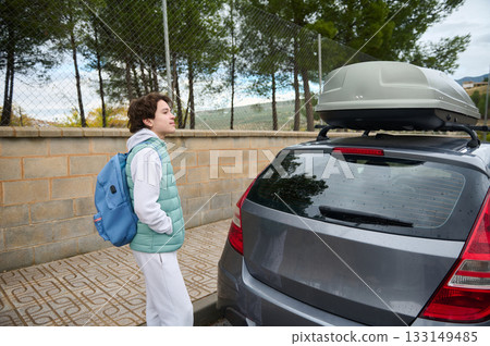 Teen Boy With Backpack Near Car With Roof Box, Ready For Adventure And Travel Today 133149485
