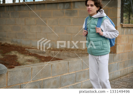 Teen Boy With Backpack Walking By Wall For School, Casual Outdoor Portrait Teen Boy With Backpack Walking By Wall For School, Casual Outdoor Portrait 133149496