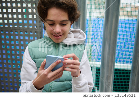 Teenage Boy With Smartphone At Playground, Casual Outdoor Portrait Reflecting Gen Z Life Teenage Boy With Smartphone At Playground, Casual Outdoor Portrait Reflecting Gen Z Life 133149521