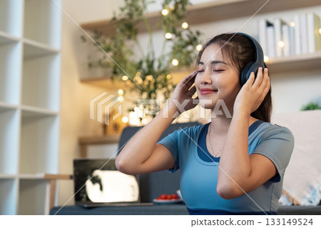 Music and Meditation. Young woman enjoying music while meditating at home. 133149524