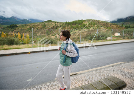 Teenage Boy With Backpack Walking Outdoors On Rural Road At Scenic Hills 133149532