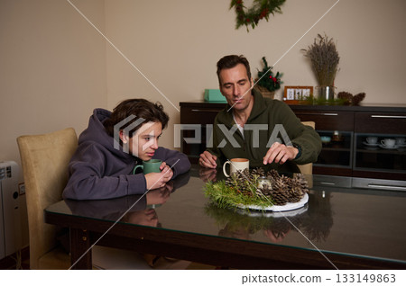 Father And Son Share Warm Coffee Moment At A Cozy Holiday Table 133149863