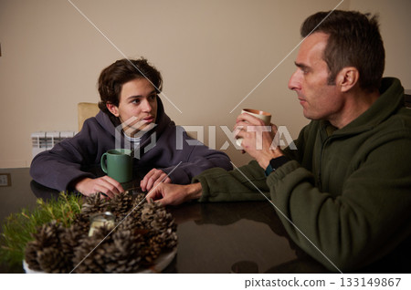 Father And Son Share A Warm Conversation At The Table In A Cozy Home Setting Father And Son Share A Warm Conversation At The Table In A Cozy Home Setting 133149867