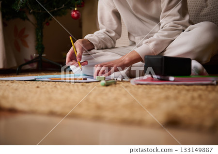 Teenage Student Studying At Home: Writing, Notebooks, And Homework By Christmas Tree Teenage Student Studying At Home: Writing, Notebooks, And Homework By Christmas Tree 133149887