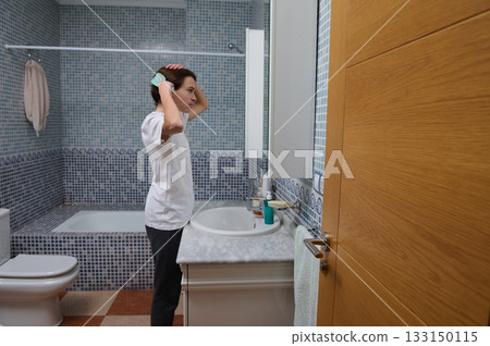 Teenage Boy Brushing Hair In Bathroom At Sink, Morning Routine In Modern Bright Home Today 133150115