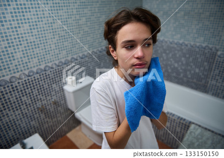 Teen Boy With Blue Towel In Bathroom Reflecting A Thoughtful Moment Teen Boy With Blue Towel In Bathroom Reflecting A Thoughtful Moment 133150150