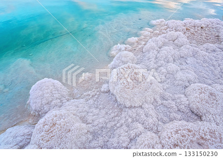 Sand completely covered with crystalline salt on shore of Dead Sea, turquoise blue water near - typical scenery at Ein Bokek beach, Israel Sand completely covered with crystalline salt on shore of Dead Sea, turquoise blue water near - typical scenery at Ein Bokek beach, Israel 133150230