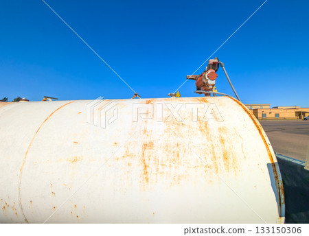 Old storage tank in an industrial area under a clear blue sky during daylight hours 133150306