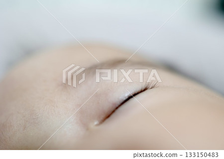 A gentle close-up photo of a baby's eyelashes and sleeping face. A gentle close-up photo of a baby's eyelashes and sleeping face. 133150483