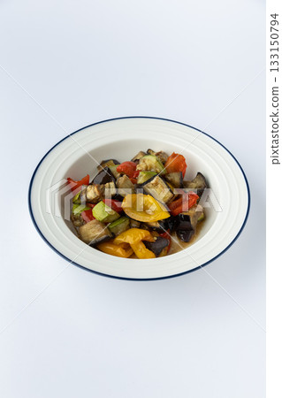 Roasted eggplant and bell pepper medley with zucchini and tomatoes, studio isolated 133150794