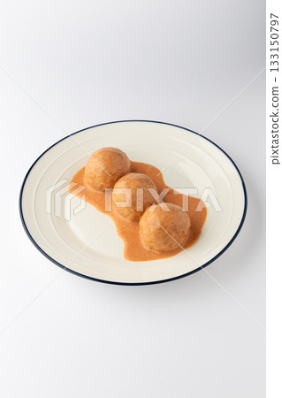 Three meatballs in creamy tomato sauce on a plate, isolated on white 133150797