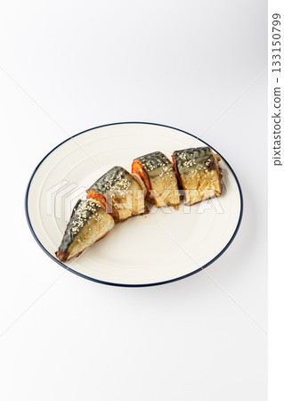 Baked mackerel slices with tomato and sesame on a white plate, isolated 133150799