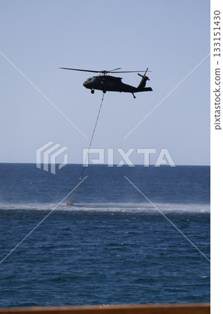Bucket carrying helicopter.a helicopter scoops up water from the sea. High quality photo Bucket carrying helicopter.a helicopter scoops up water from the sea. High quality photo 133151430