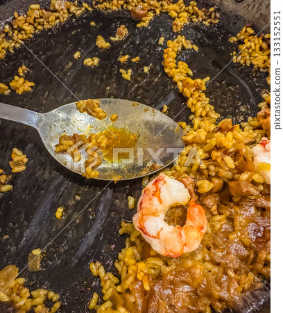 shot of traditional Spanish paella rice with shrimp and spoon in the pan after serving. Authentic Mediterranean cuisine and homemade food concept. High quality photo 133152551