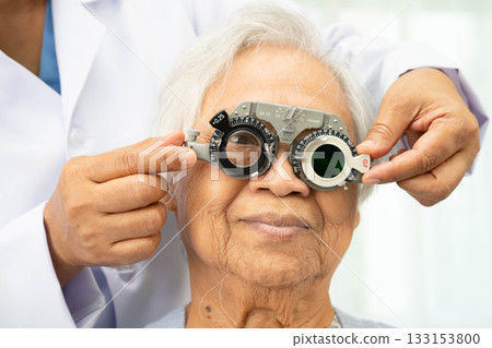 Asian senior woman wearing ophthalmic vision eye test and using optical trial frame. Asian senior woman wearing ophthalmic vision eye test and using optical trial frame. 133153800