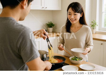A Japanese couple cooking pasta together in the kitchen during the day 133153816