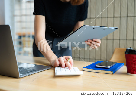 Close up of businesswoman or accountant hand typing laptop working to calculate on desk about cost 133154203